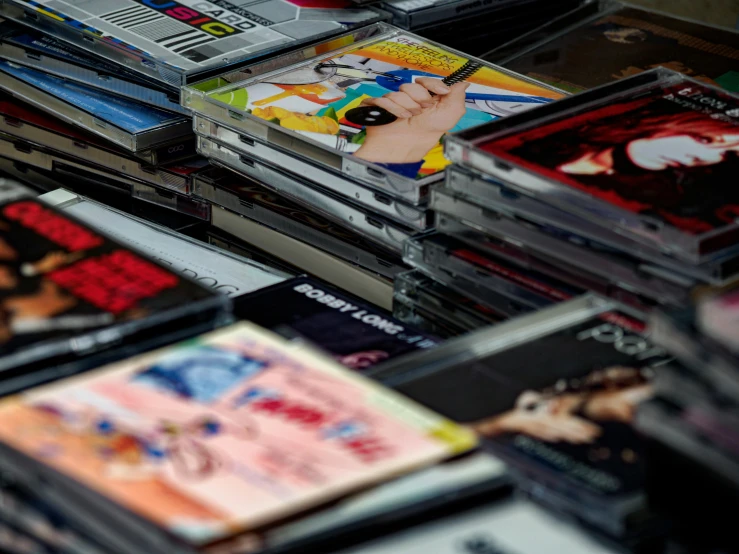 a pile of cds sitting on top of a table, an album cover, unsplash, computer art, cigarrette boxes at the table, jewel case, comic books, late 90s