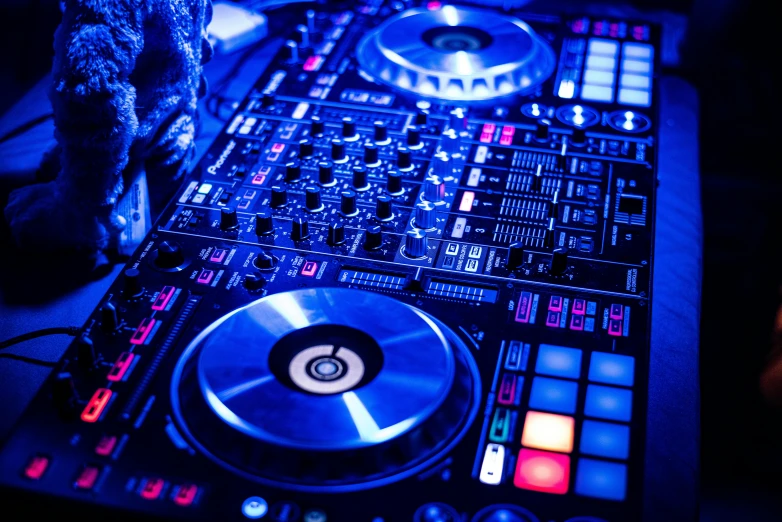 a dj controller sitting on top of a table, pexels, process art, blue and red lights, mix between tribal and hi-tech, college party, avatar image