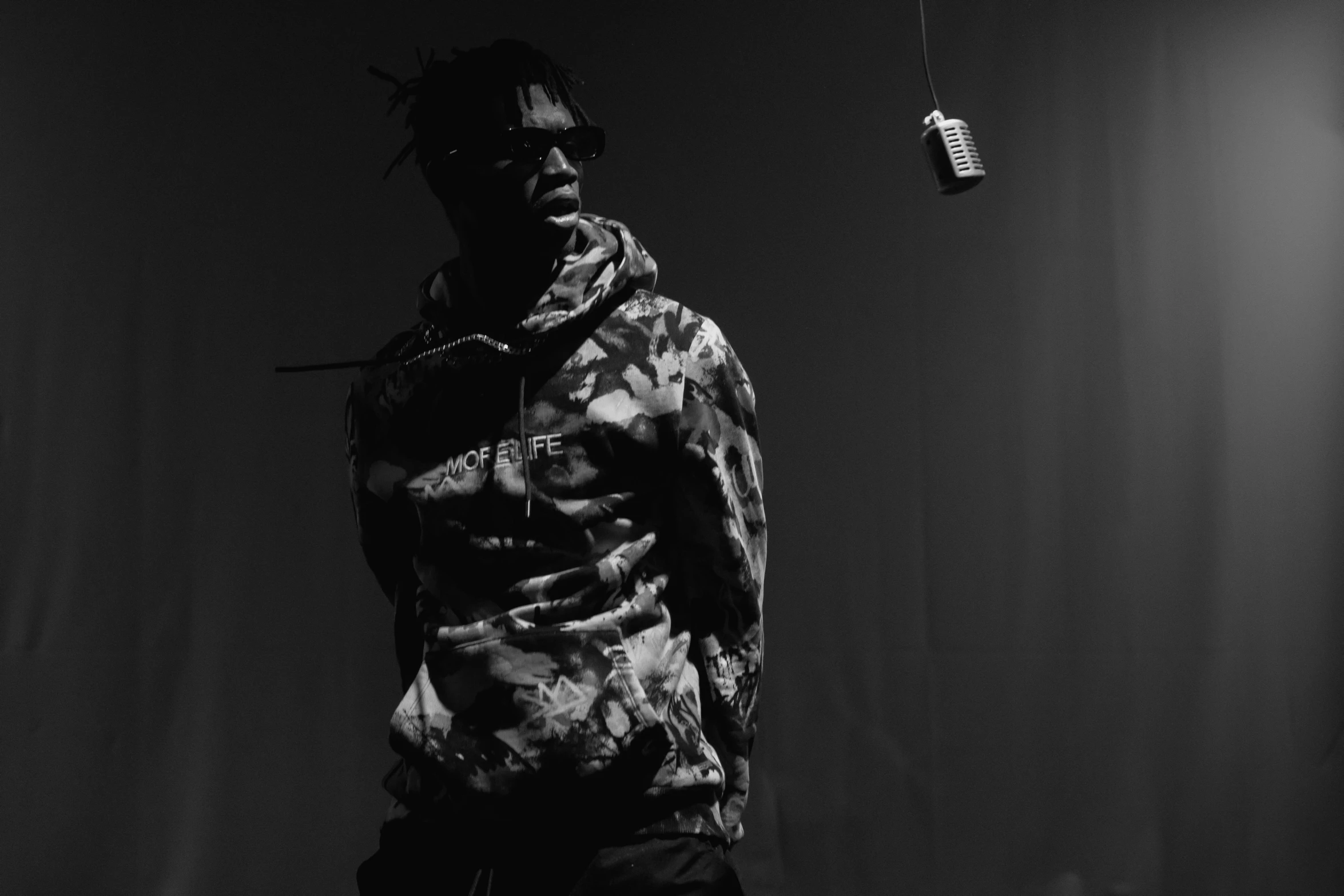a man that is standing in the dark, an album cover, unsplash, visual art, young thug, monochrome:-2, wearing camo, live performance