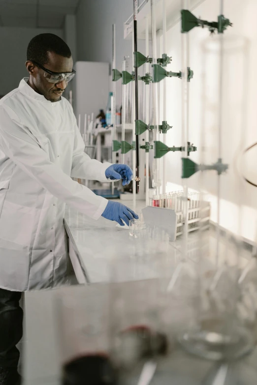 a man in a lab coat working in a laboratory, pexels, sustainable materials, low quality photo, panel, keter class