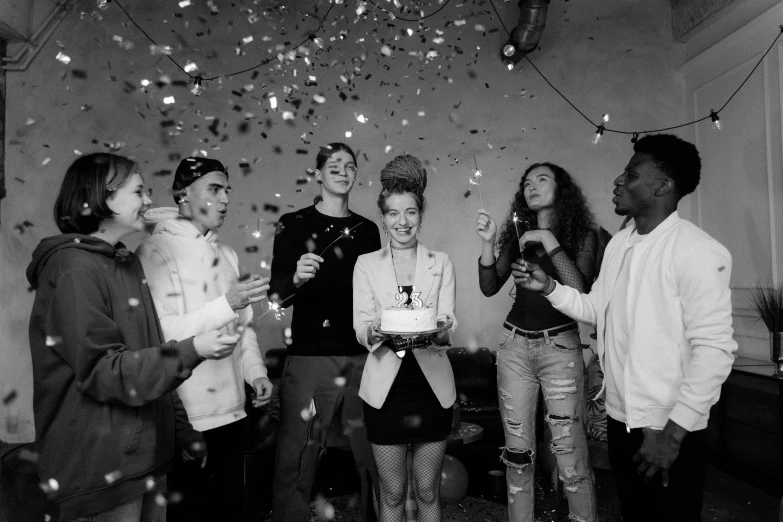 a group of people standing around a cake, a black and white photo, pexels contest winner, antipodeans, confetti, young lady, millennial vibes, happy birthday