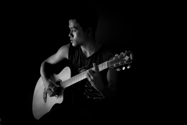 a black and white photo of a man playing a guitar, by Alejandro Obregón, pexels contest winner, realism, young man, isolated, portrait!!!!!!, portrait of gigachad