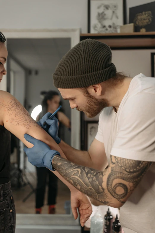 a man getting a tattoo on a woman's arm, a tattoo, by Adam Marczyński, trending on pexels, hyperrealism, mac miller, color footage, skin : tjalf sparnaay, male model