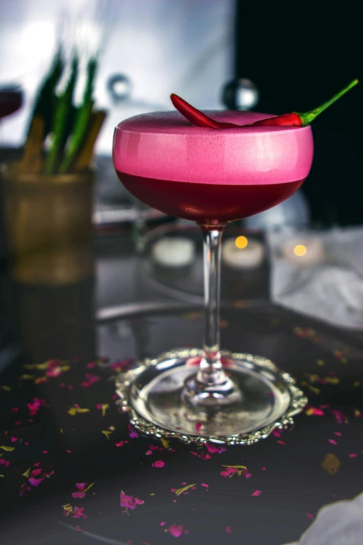 a pink cocktail sitting on top of a table, inspired by Cosmo Alexander, red and obsidian neon, spicy, handcrafted, ready to eat