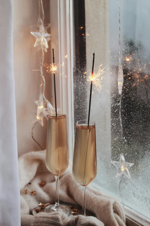 a couple of champagne glasses sitting on top of a window sill, large star crystals, bright thin wires, lit from the side, charcoal and champagne