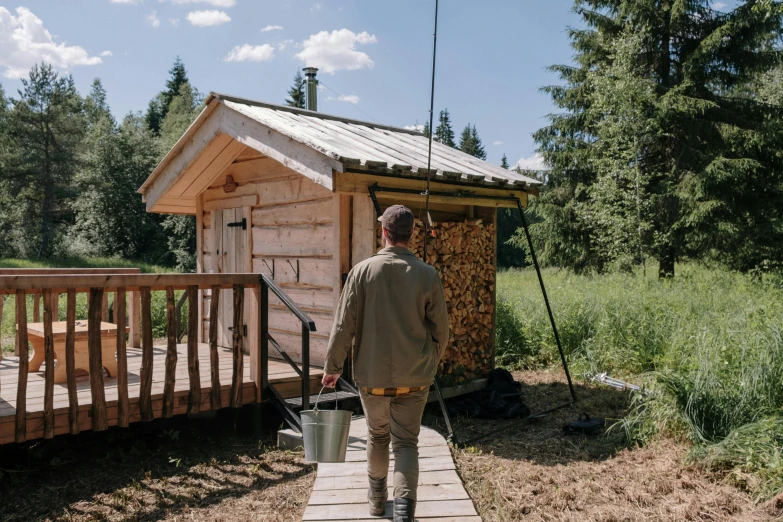 a man standing in front of a small cabin, by Julia Pishtar, sauna, high quality upload, fishing, thumbnail