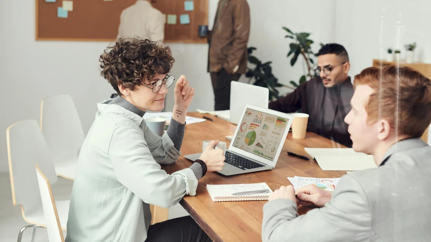 a group of people sitting around a wooden table, a cartoon, pexels contest winner, using a macbook, wearing business casual dress, avatar image, mid shot photo