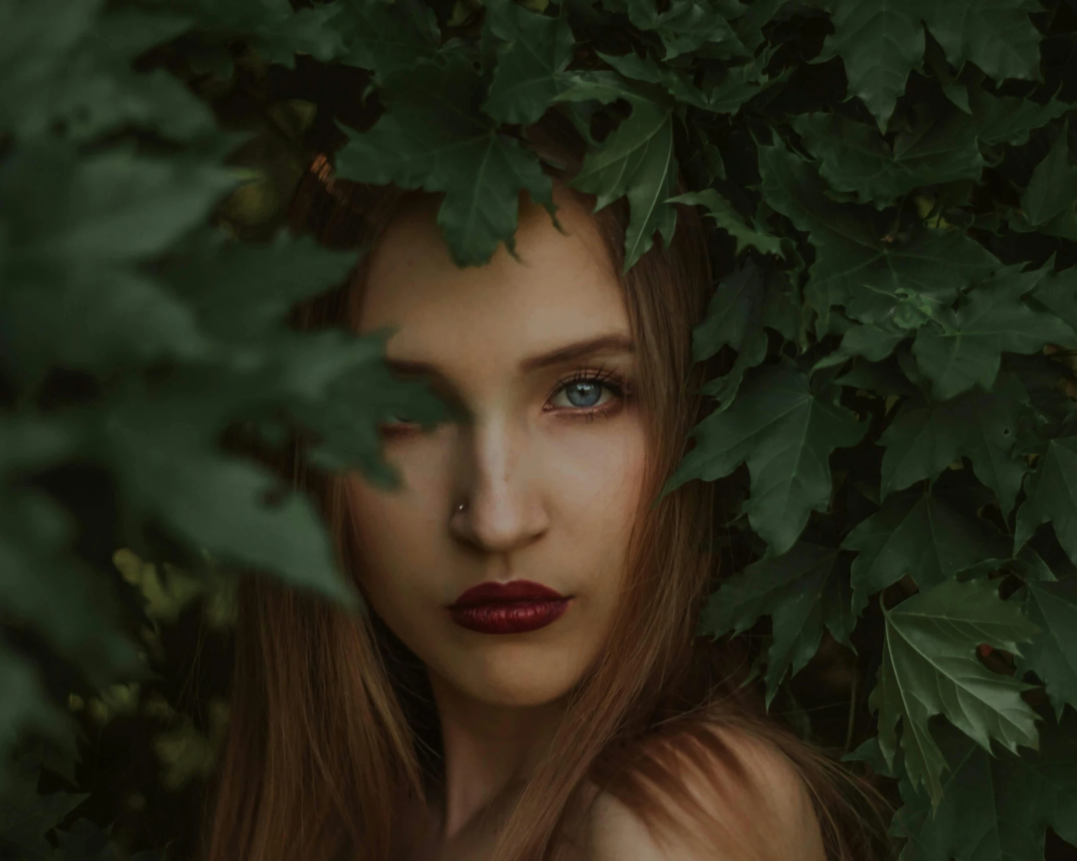 a woman with long red hair standing in front of a bush, inspired by Elsa Bleda, pexels contest winner, aestheticism, green eyes fine face pretty face, eyes and lips, branches and ivy, perfect face )