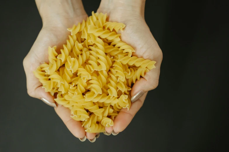 a person holding a handful of pasta in their hands, by Carey Morris, pexels, fan favorite, animation, ruffles, rice