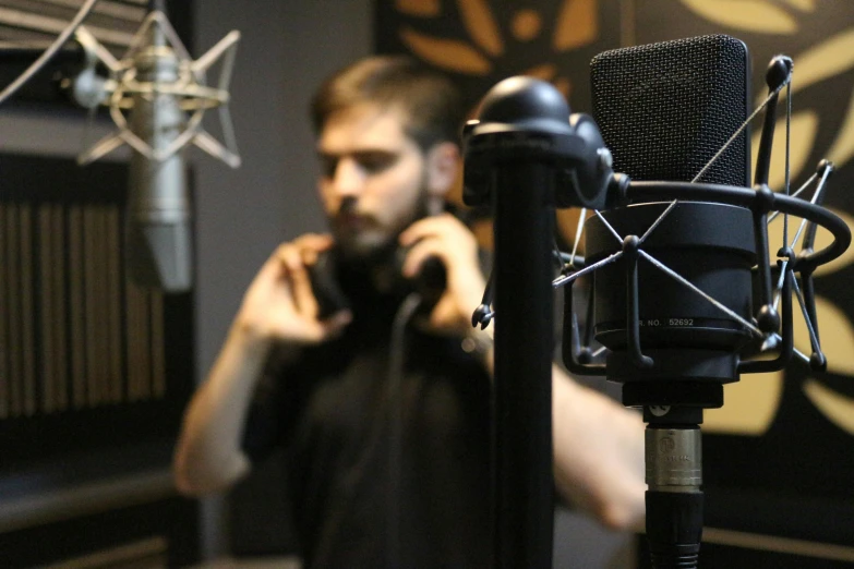 a man talking on a cell phone in front of a microphone, production ig, elias chatzoudis, **cinematic, thumbnail