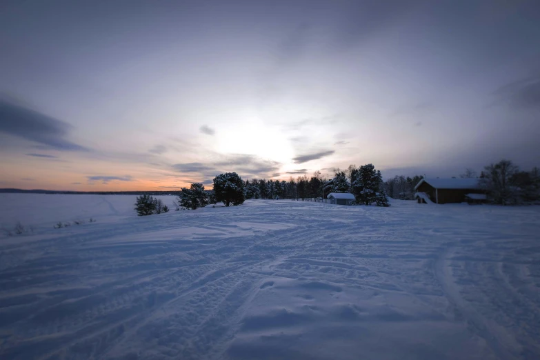 a snow covered field with a house in the distance, inspired by Eero Järnefelt, pexels contest winner, panorama view of the sky, evening at dusk, grey, gopro photo