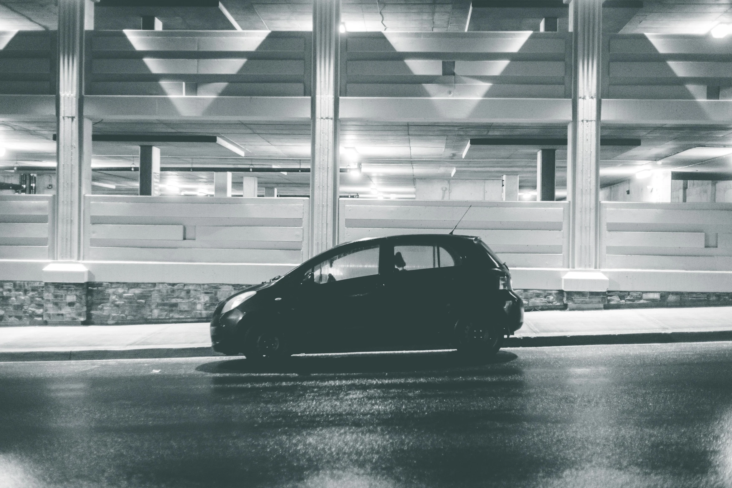 a black and white photo of a car in a parking garage, pexels contest winner, square, night outside, cute photo, high resolution photo