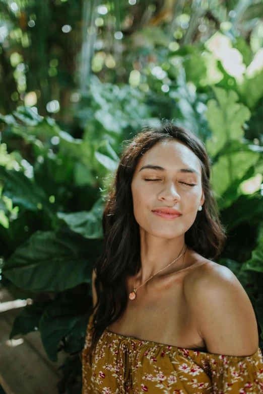 a woman sitting on a bench with her eyes closed, trending on unsplash, in the background is lush jungle, oiled skin, luminous body, profile image