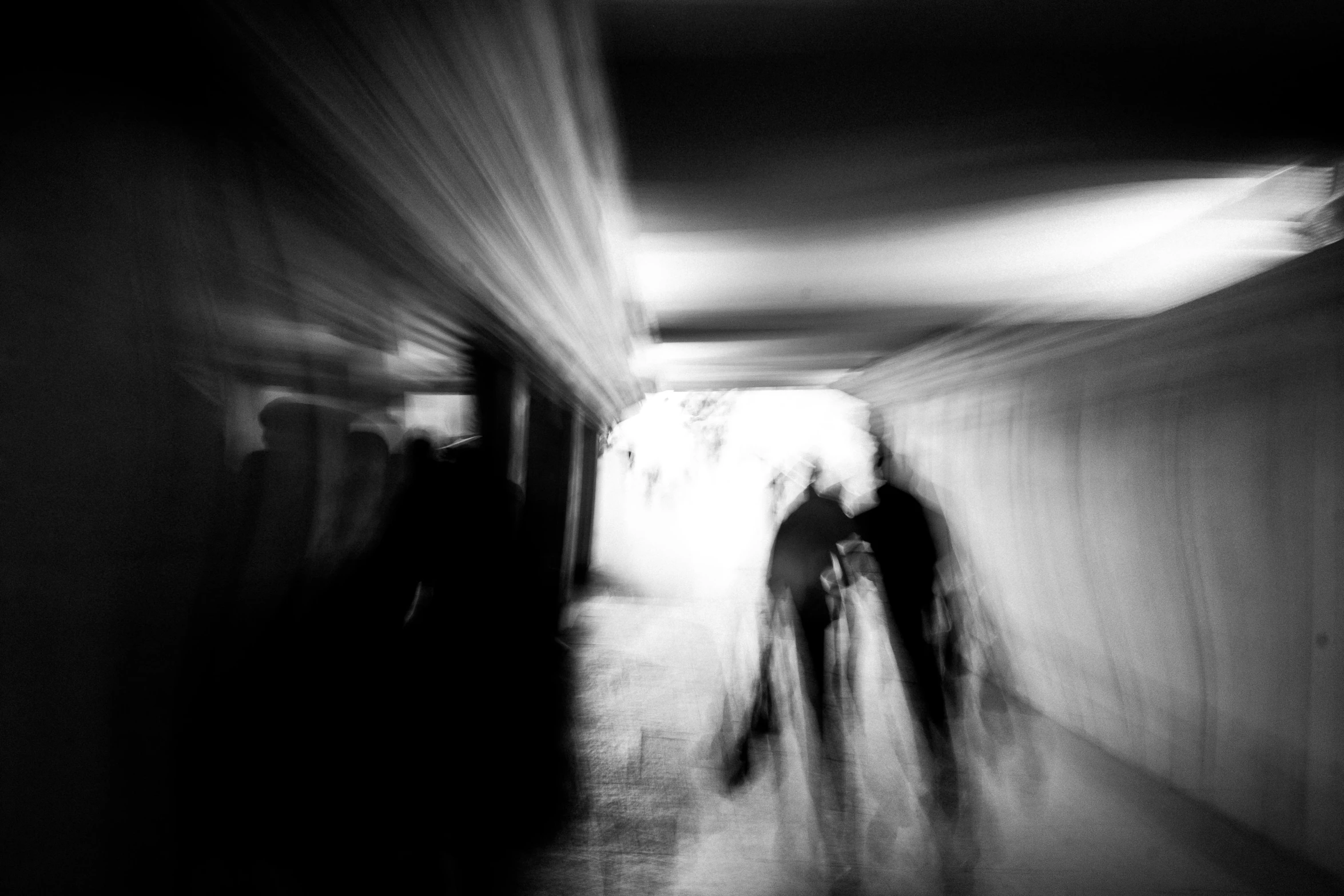 a blurry photo of two people walking down a hallway, a black and white photo, by Mirko Rački, conceptual art, crowded silhouettes, in the astral plane ) ) ), abstract horror, nika maisuradze