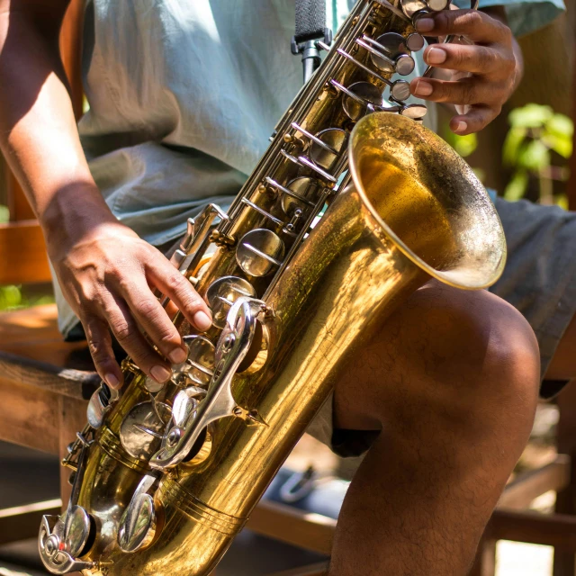 a man sitting on a bench playing a saxophone, pexels contest winner, close-up on legs, australian, al fresco, a wooden