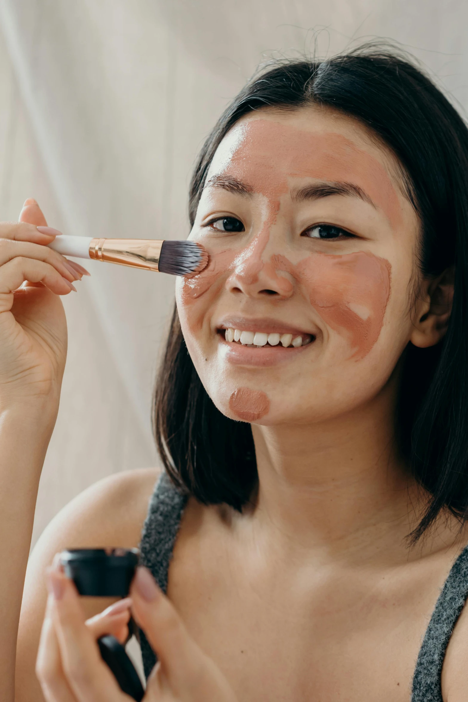 a woman brushes her face with a brush, by Julia Pishtar, trending on pexels, renaissance, right - half a cheerful face, nezuko, tan skin, prosthetic makeup