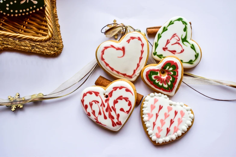 a bunch of decorated cookies sitting on top of a table, by Sylvia Wishart, pexels, arabesque, hearts symbol, candy canes, white, thumbnail