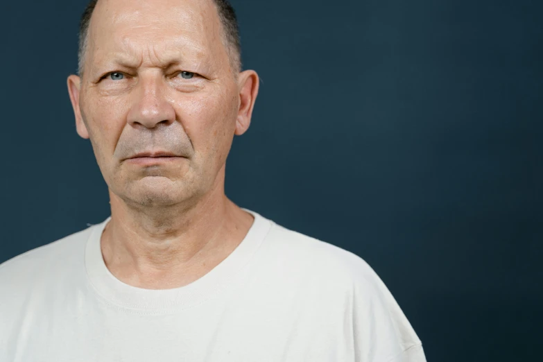a man in a white shirt looking at the camera, unsplash, hyperrealism, grumpy [ old ], colour photograph, plain background, 15081959 21121991 01012000 4k