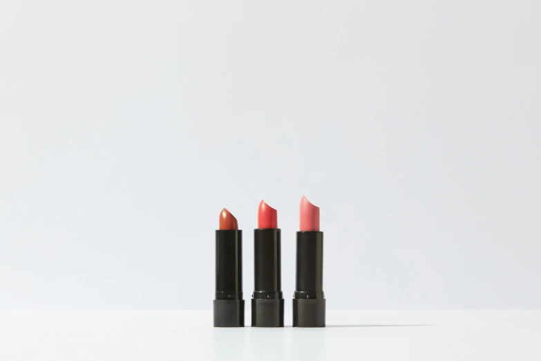 three lipsticks sitting side by side on a white surface, by Gavin Hamilton, covered in coral, manuka, modern minimalist f 2 0, assemble