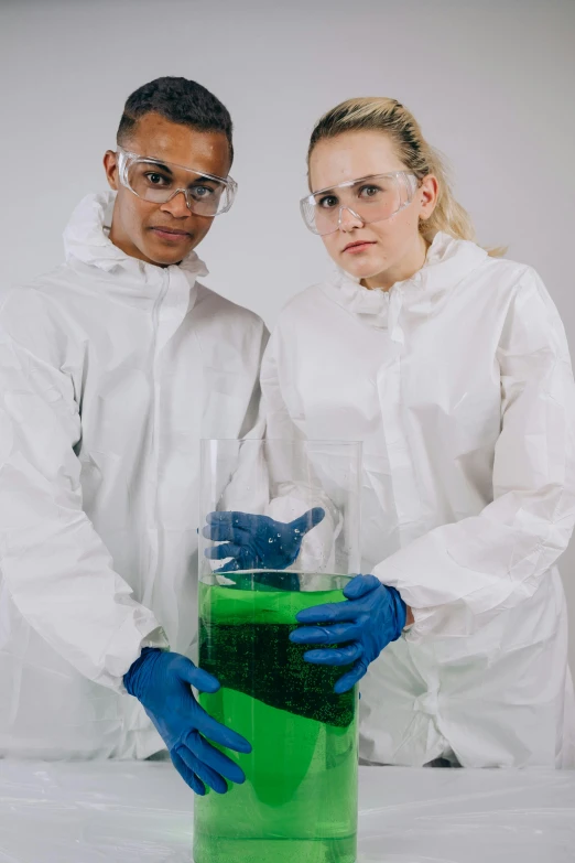 a couple of people standing next to each other, chemicals, looking serious, academic clothing, synthetic skin