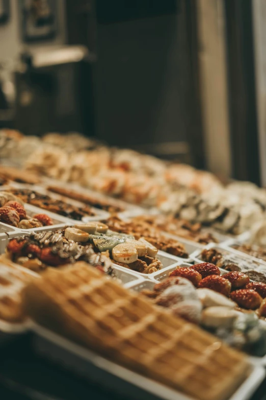 a row of waffles sitting on top of a counter, a tilt shift photo, by Niko Henrichon, trending on pexels, arabesque, candy shop in a mall, thumbnail, shelves full of medieval goods, melbourne