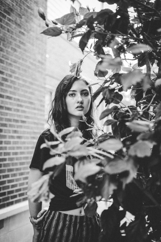 a woman standing in front of a tree, a black and white photo, by Felix-Kelly, maisie williams, grunge aesthetic!!! (, vine covered, may)