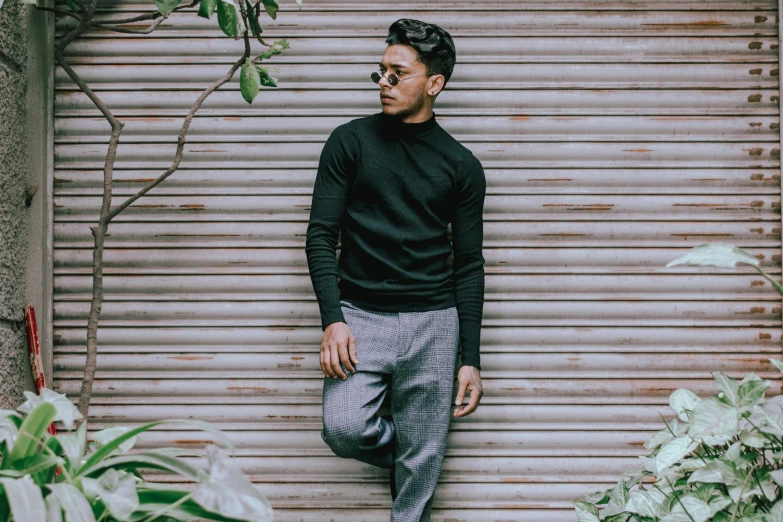 a man standing in front of a garage door, pexels contest winner, black turtleneck, grey pants and black dress shoes, nivanh chanthara, thumbnail