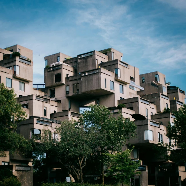 a tall building sitting on top of a lush green field, by Washington Allston, unsplash, brutalism, habitat 67, staggered terraces, 1970s photo, architecture and more