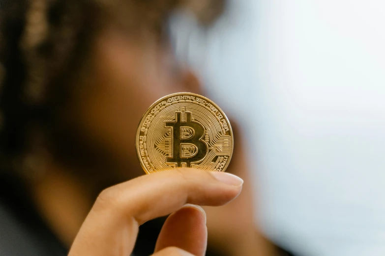 a person holding a bit coin in their hand, a picture, trending on unsplash, hurufiyya, avatar image, a woman's profile, thumbnail, small in size