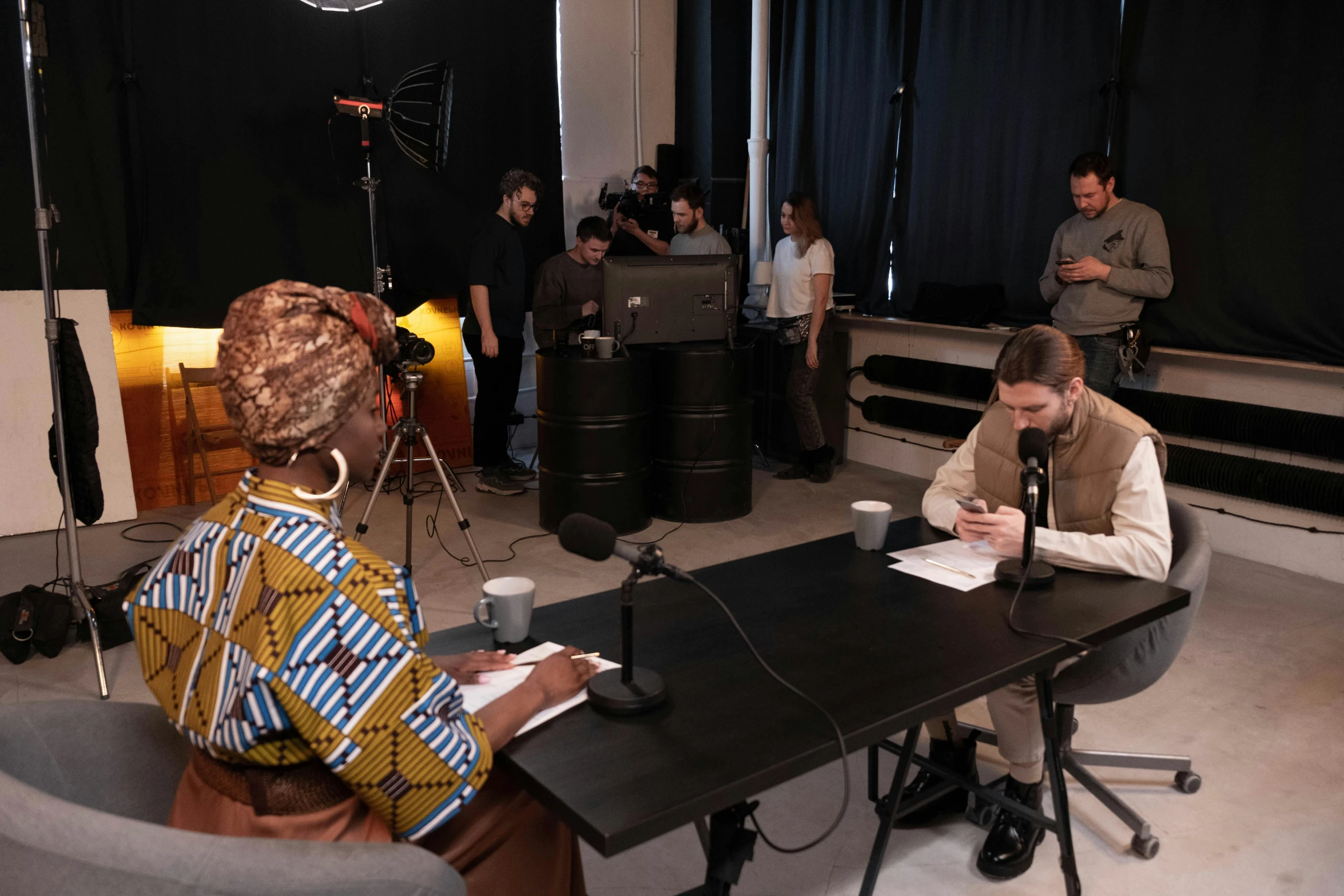 a group of people sitting around a table, studio recording, xqc, imane anys, two still figures facing camera