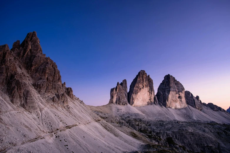 a mountain range with some very tall mountains in the background, by Carlo Martini, pexels contest winner, tall stone spires, blue hour, panoramic, subtle detailing