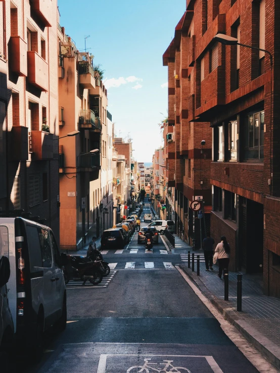 a street filled with lots of traffic next to tall buildings, by Luis Molinari, spanish alleyway, high quality image”