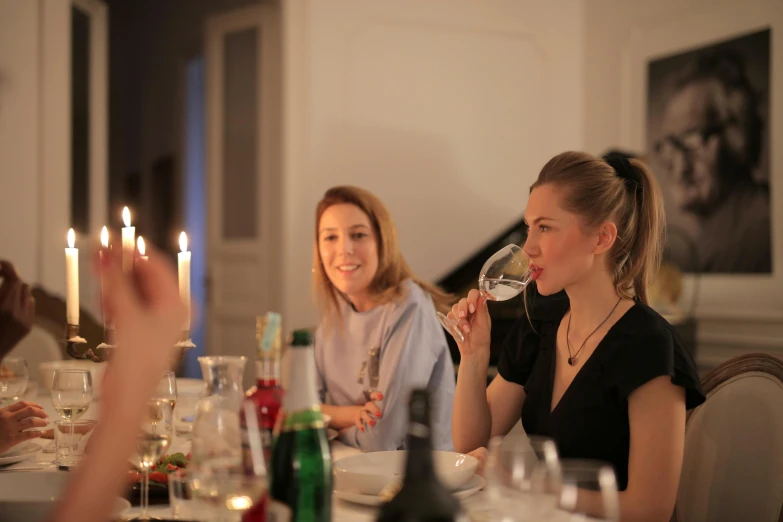 a group of people sitting around a table drinking wine, profile image