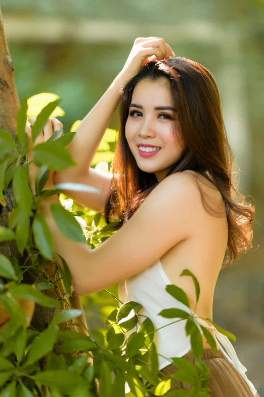 a beautiful young woman standing next to a tree, by Reuben Tam, square, asian woman, lush surroundings, portrait image