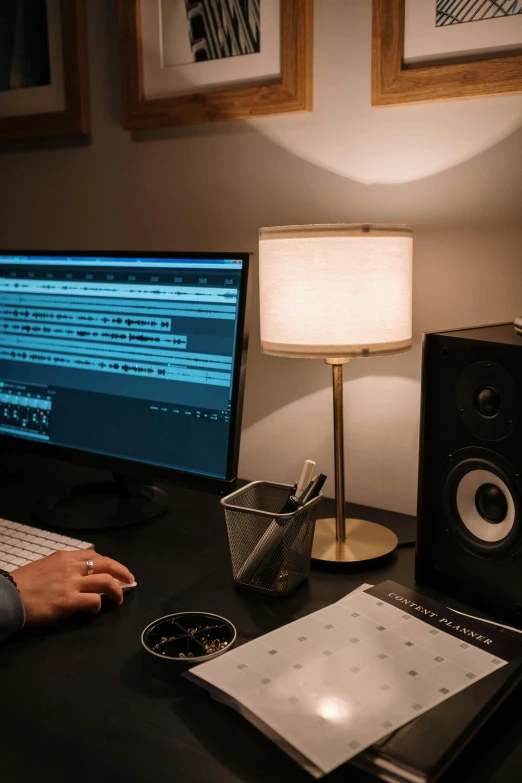 a man sitting at a desk in front of a computer, an album cover, by Robbie Trevino, pexels contest winner, studio lights, sheet music, mixing, unedited