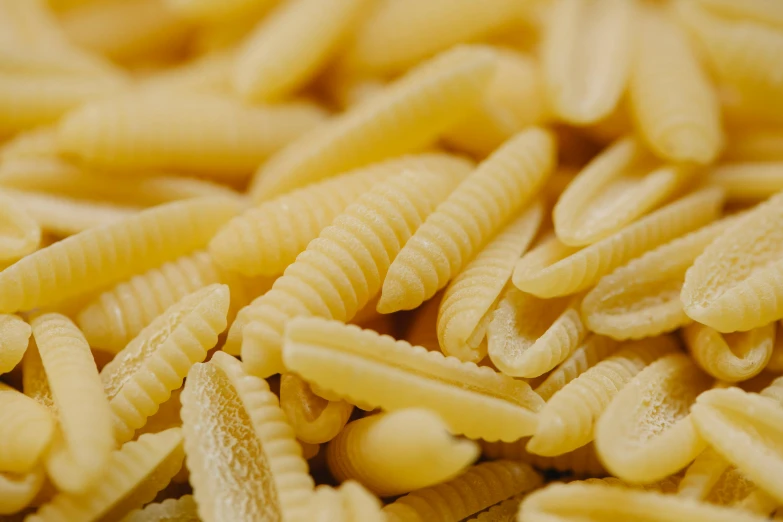 a pile of pasta sitting on top of a table, a macro photograph, by Carey Morris, pexels, rows of razor sharp teeth, thumbnail, vanilla, a pair of ribbed