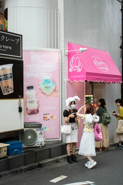 a group of people standing on the side of a road, a poster, by Shinoda Toko, instagram, colored milk tea, candy shop in a mall, white and pink cloth, fresh bakeries in the background