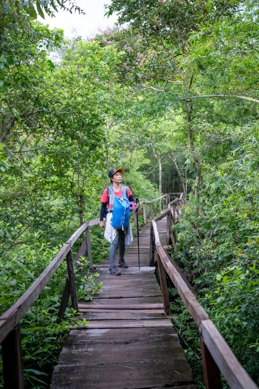 a couple of people that are standing on a bridge, by Anna Haifisch, sumatraism, angkor thon, on forest path, descent, wearing adventuring gear