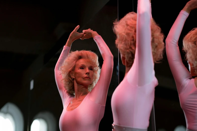 a woman that is standing in front of a mirror, an album cover, pexels, arabesque, in the movie lifeforce (1985) 8k, dolly parton, female dancer, pink body