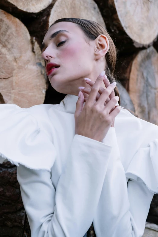 a woman standing in front of a pile of logs, inspired by Elsa Bleda, trending on pexels, renaissance, white soft leather model, puff sleeves, neck zoomed in from lips down, gloves and jewelry. motion