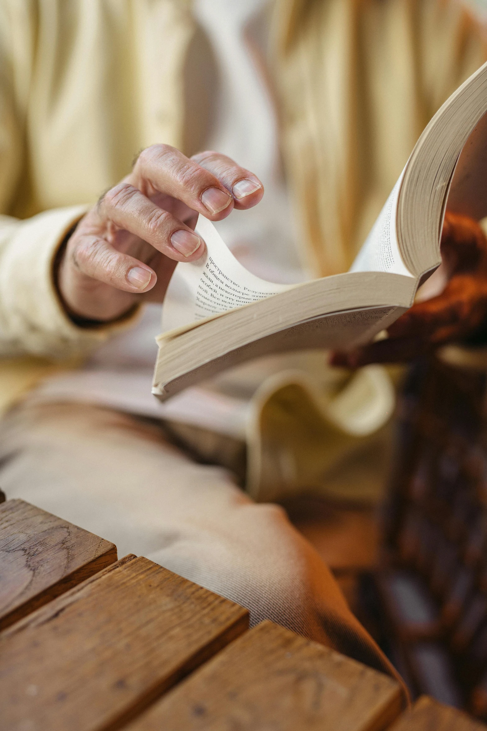 a man sitting at a table reading a book, by Dan Content, trending on unsplash, renaissance, holy ceremony, holding a wood piece, 15081959 21121991 01012000 4k, dynamic closeup