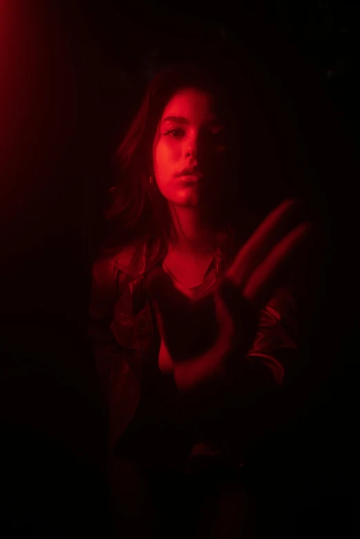 a woman standing in front of a red light, inspired by Elsa Bleda, digital art, madison beer girl portrait, dark. studio lighting, glowing hands, cinematic shot ar 9:16 -n 6 -g