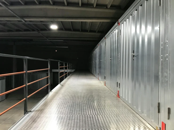 a long metal walkway inside of a building, cupboards, ultrastation hq, dark. no text, indoor picture