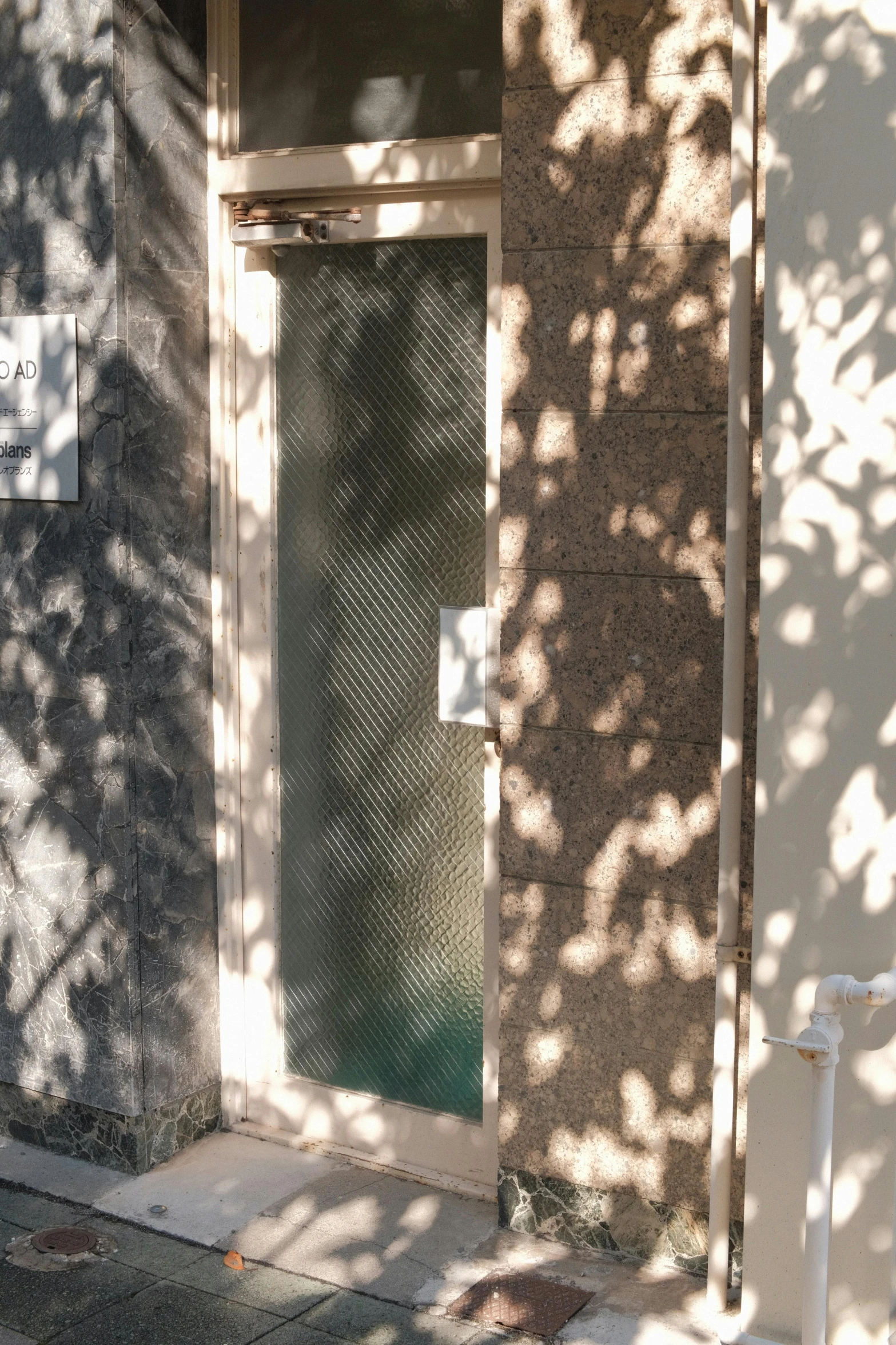 a red fire hydrant sitting on the side of a street, an album cover, inspired by Peter Zumthor, unsplash, light and space, trees cast shadows on the wall, translucent glass shine, doorway, brown