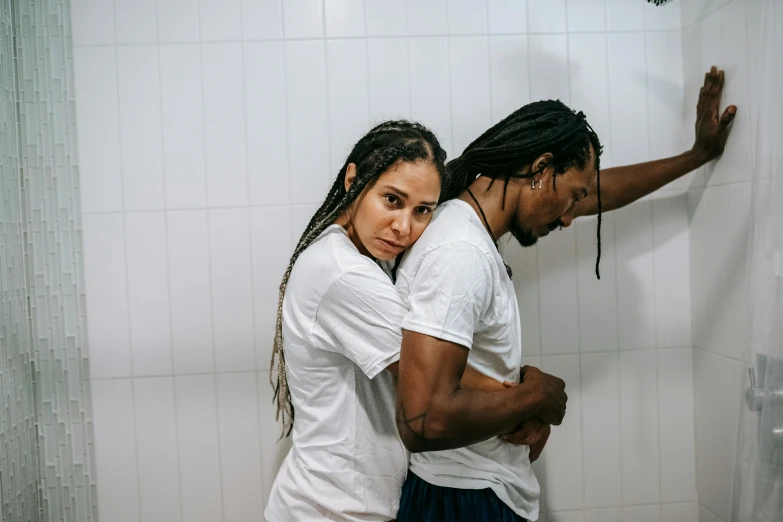 two people standing next to each other in a bathroom, by Lucia Peka, pexels contest winner, dreadlock black hair, wearing a tee shirt and combats, man grabbing a womans waist, thumbnail