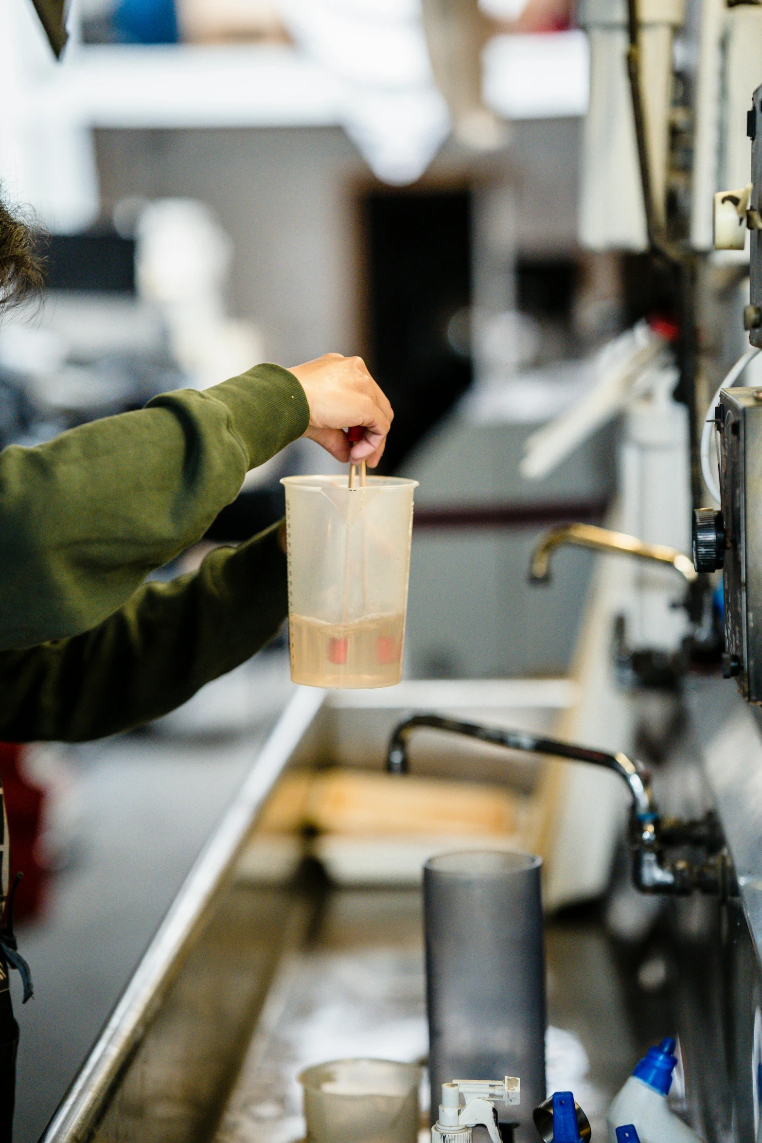 a man that is standing in front of a machine, a silk screen, trending on unsplash, cold brew coffee ), ignant, woodturning, fluids