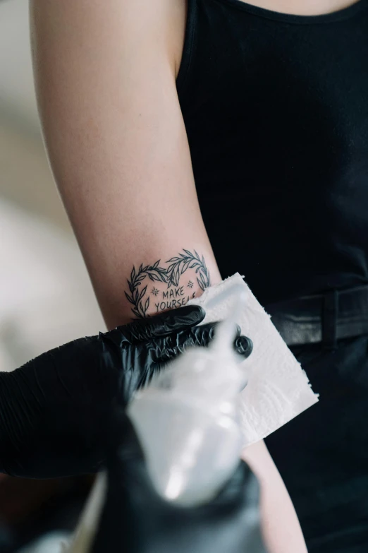 a woman with a tattoo on her arm, trending on pexels, wearing gloves, plastic skin, ink and paper, small