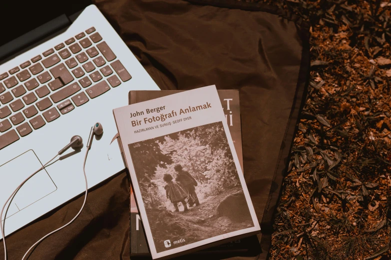 a book sitting next to a laptop computer, a black and white photo, art & language, lying on the woods path, background image, cinematic outfit photo, thumbnail