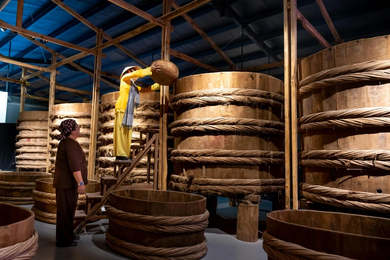 a man that is standing in front of a bunch of barrels, inspired by Li Di, preserved museum piece, ropes, cai xukun, 2 0 2 2 photo