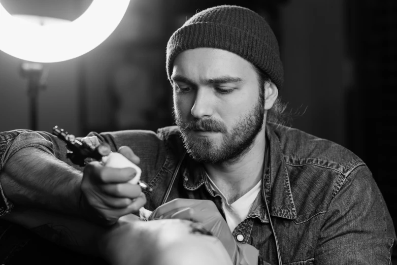 a black and white photo of a man getting a tattoo, a tattoo, by Adam Marczyński, pexels, model painting, glowing tattoos, portrait realistic photograph, man